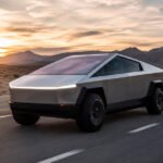 Tesla Cybertruck futuristik melaju di jalan terbuka dengan desain modern dan teknologi kendaraan listrik.